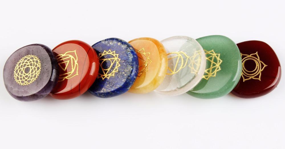 Set of colorful stones with gold geometric designs on a white background
