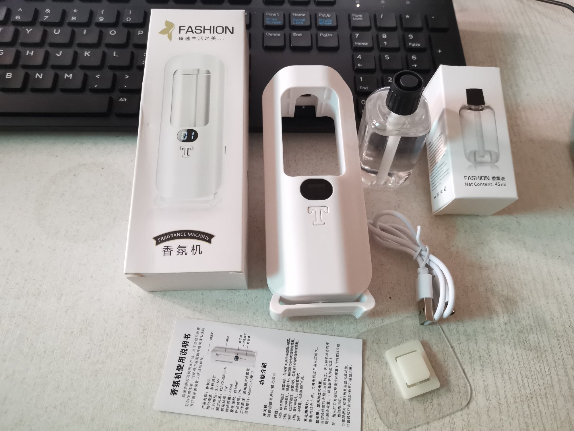 Personal fragrance machine with packaging and accessories on a desk