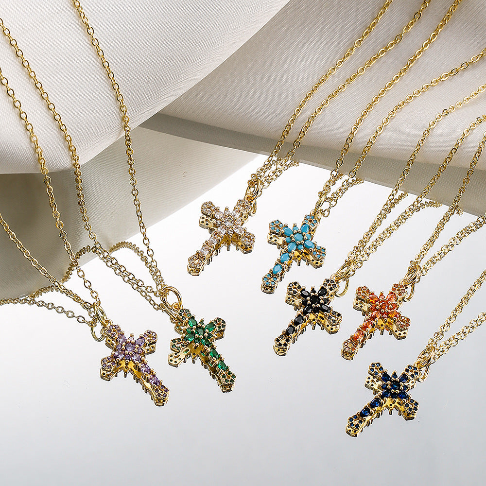 Gold cross necklaces with gemstone accents on a light background