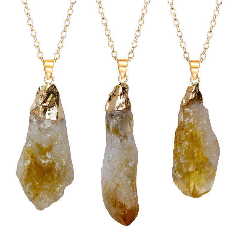 Three crystal pendants on gold chains against a white background