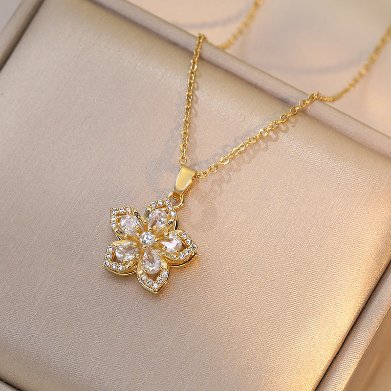 Gold necklace with a floral pendant on a beige background