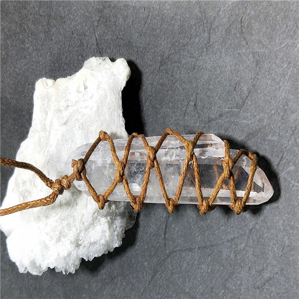 Crystal point with woven brown cord on a gray background