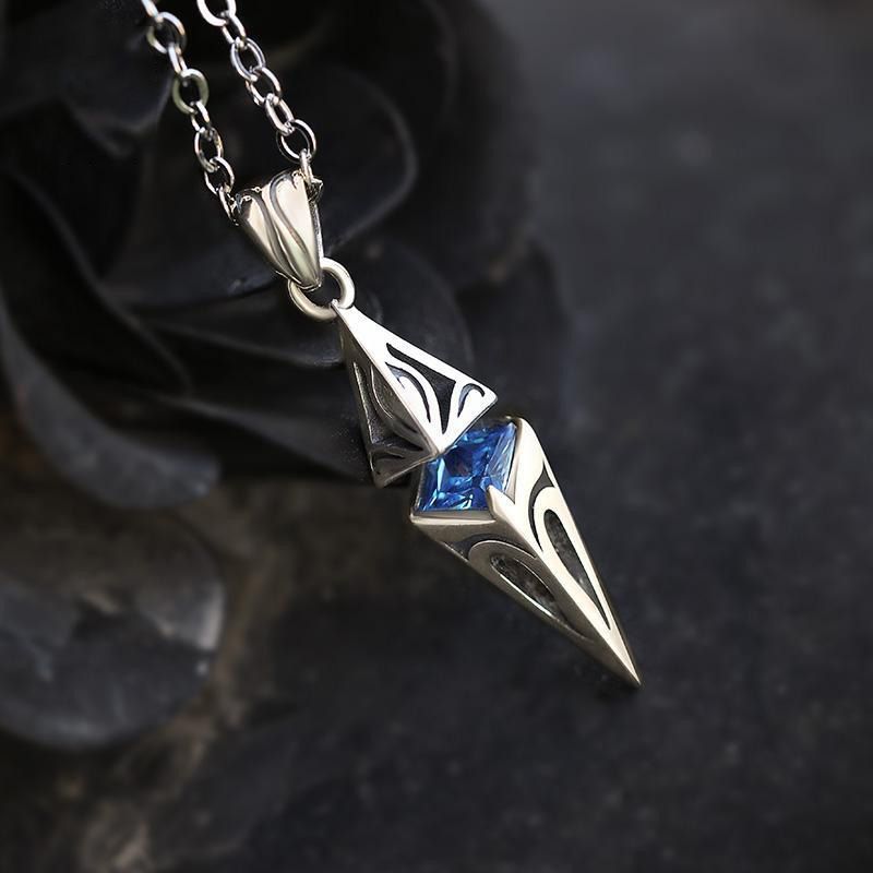 Silver pendant with a blue gemstone on a dark background