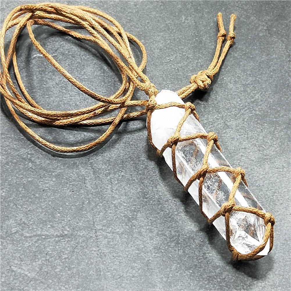 Crystal pendant with woven string on a gray background
