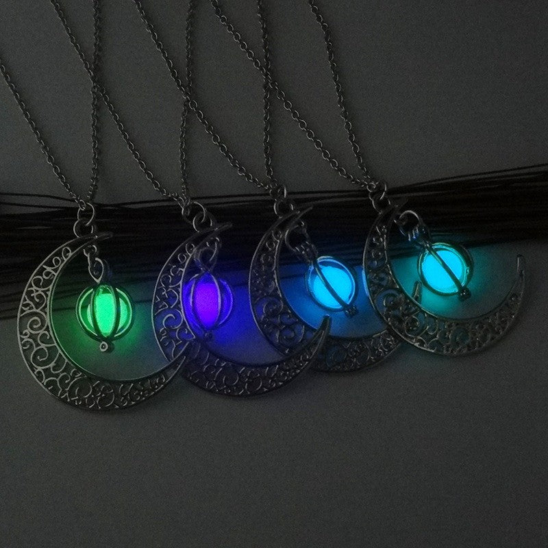Set of four glowing necklaces with crescent moon designs on a dark background