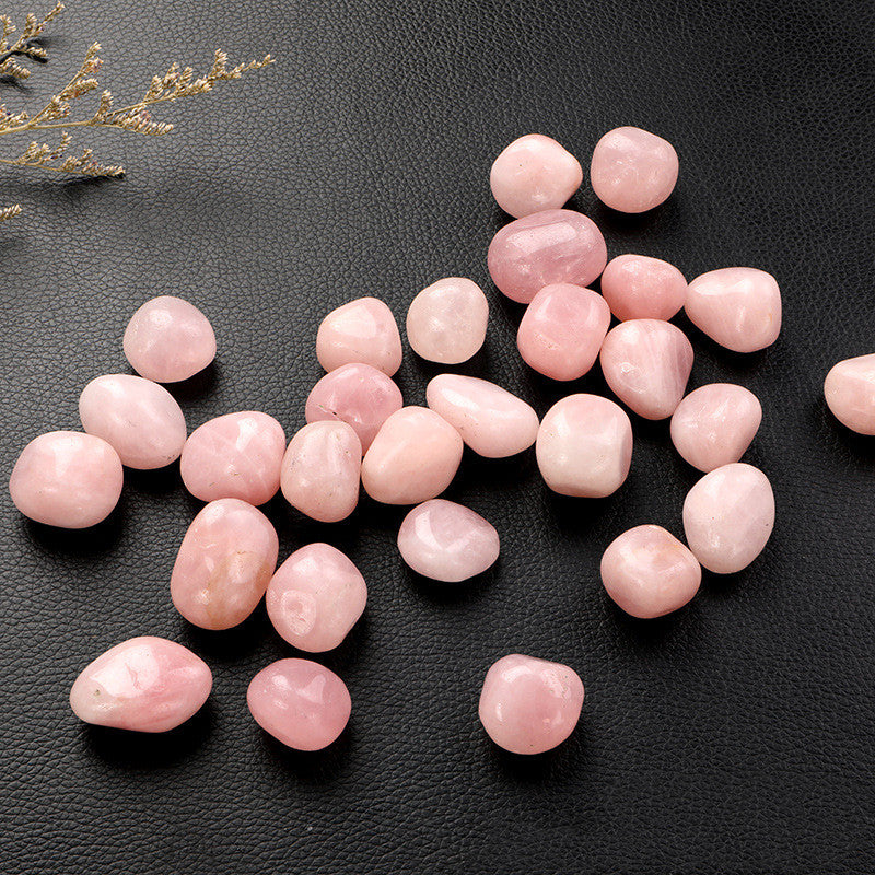 Pink stones on a black textured surface with decorative elements.