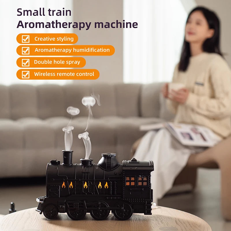 Small train-shaped aromatherapy machine with features listed on a blurred background of a person sitting on a couch.