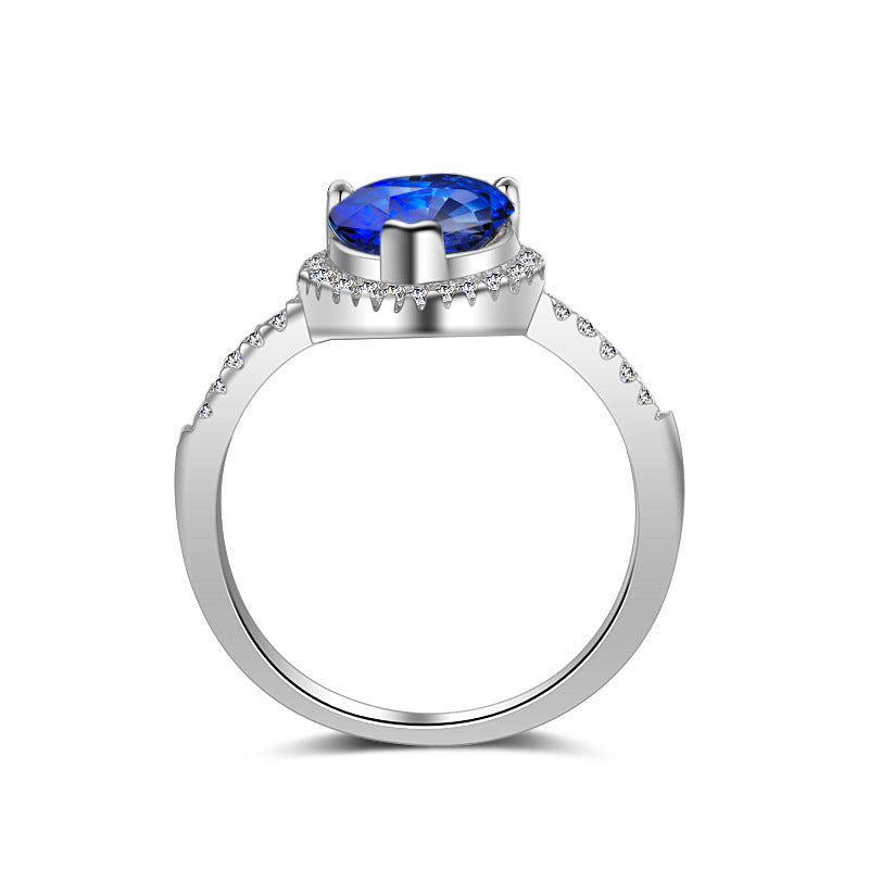 Silver ring with a blue gemstone on a white background