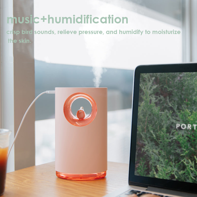 Pink humidifier on a desk with a laptop and drink, featuring text about music and humidification.