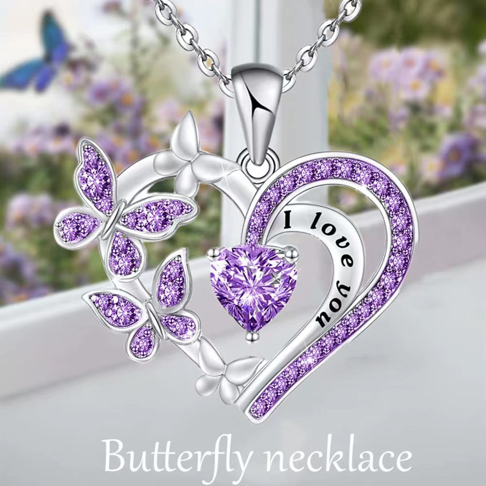 Butterfly necklace with purple heart and 'I love you' engraving on a blurred floral background