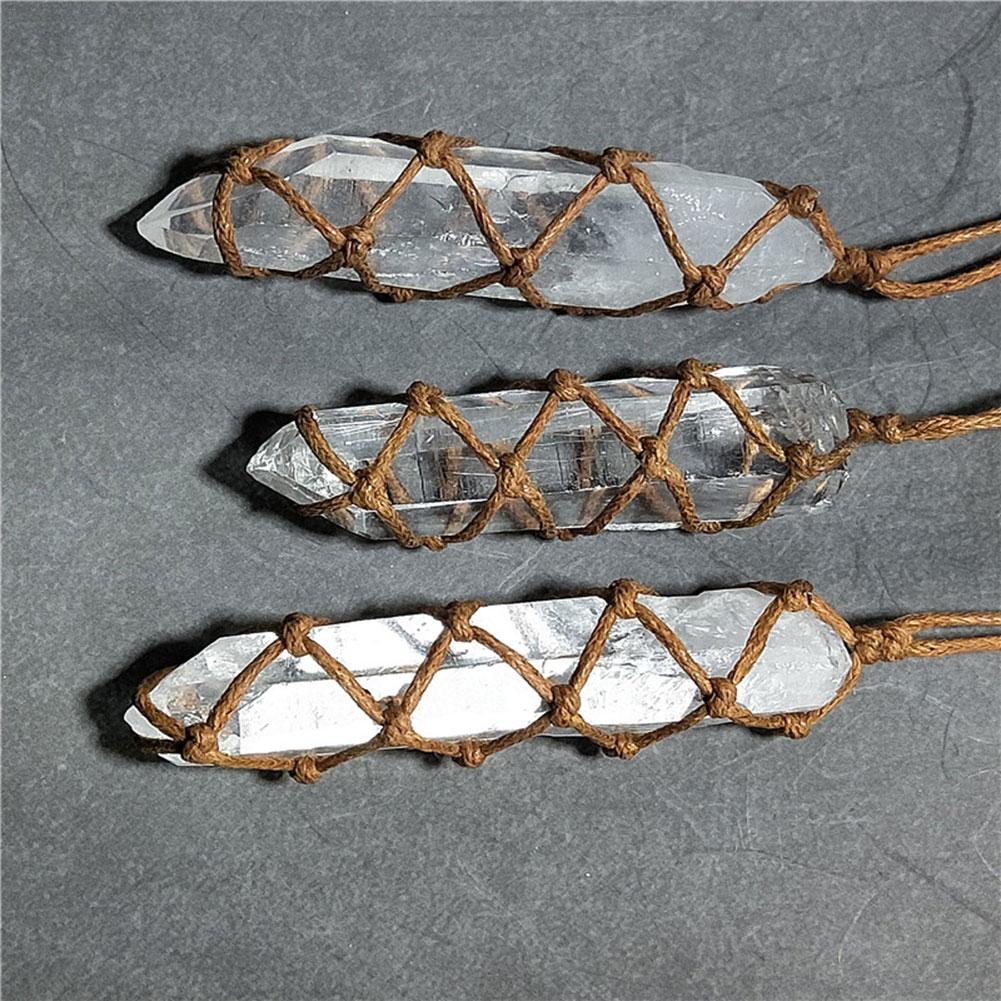 Three crystal points wrapped with brown rope on a gray background