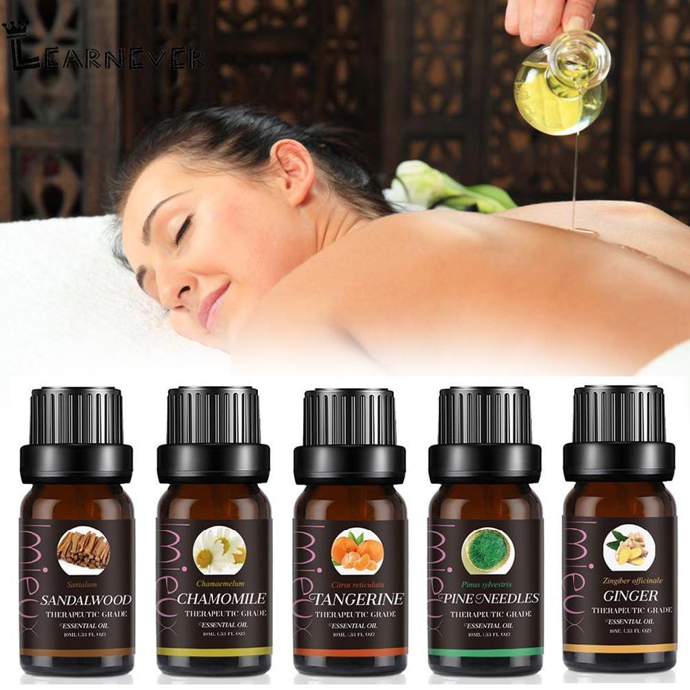 Set of essential oil bottles with a blurred background of a woman receiving a massage.