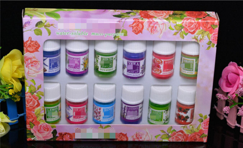 Set of small bottles with colorful labels in a decorative box with floral design