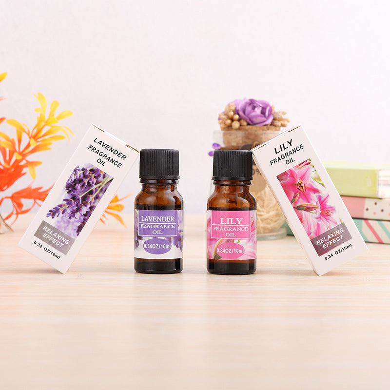 Two small fragrance oil bottles with their respective labels on a light surface.