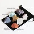 Set of various crystals on a black drawstring bag with labels.