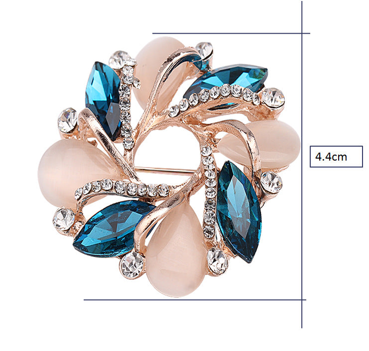 Decorative brooch with blue gemstones and pearls on a white background