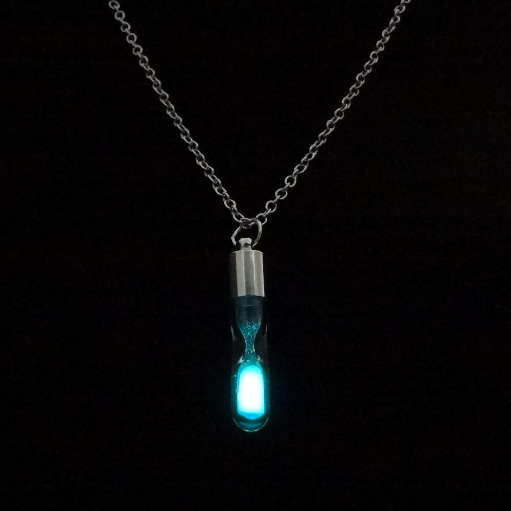 Necklace with a glowing blue pendant on a black background