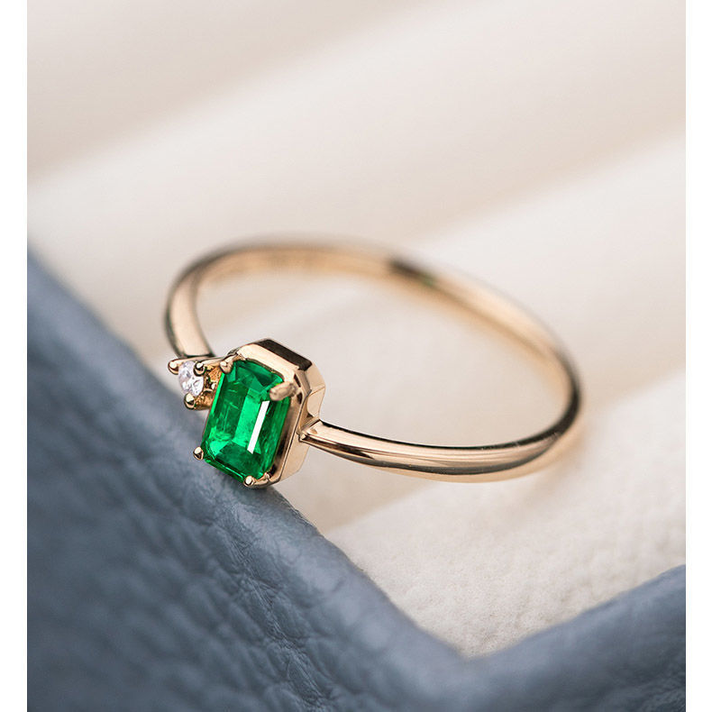 Gold ring with a green gemstone on a soft background