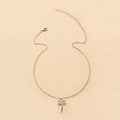 Gold necklace with a palm tree pendant on a beige background