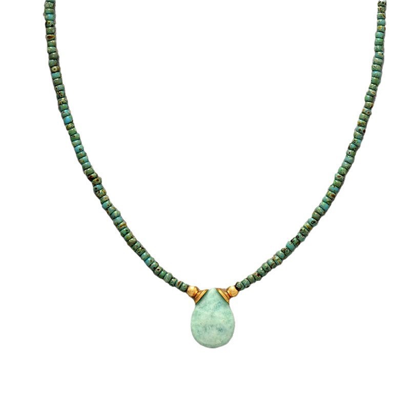 Necklace with green beads and a teardrop pendant on a white background
