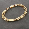 Gold bracelet with cross designs on a dark gray background