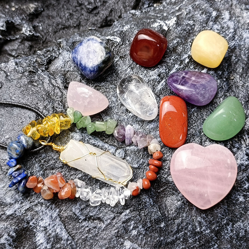 Assorted colorful crystals and a necklace on a textured surface