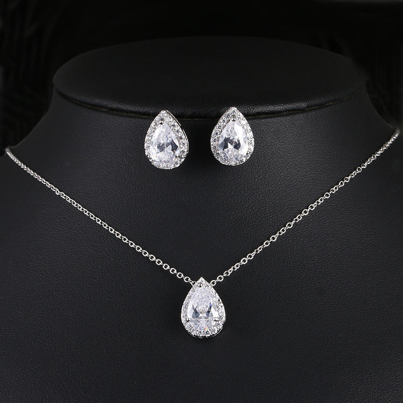 Jewelry set with teardrop-shaped earrings and necklace on a black mannequin.