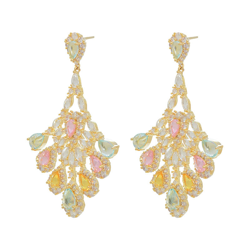 Gold earrings with multicolored gemstones on a white background