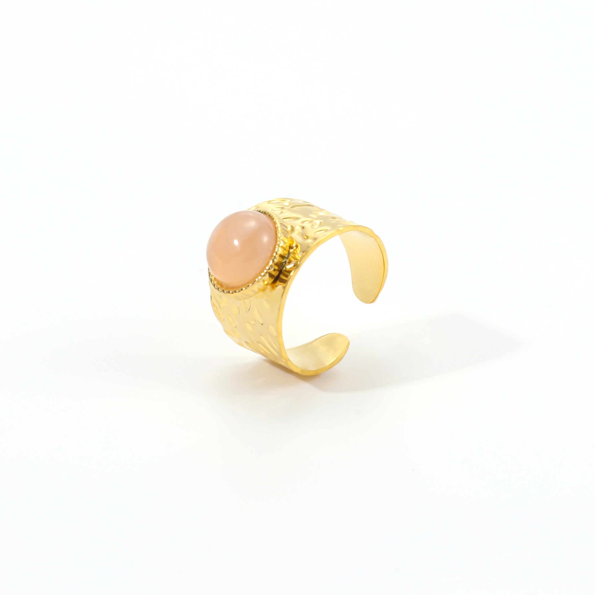 Gold ring with a pink stone on a white background