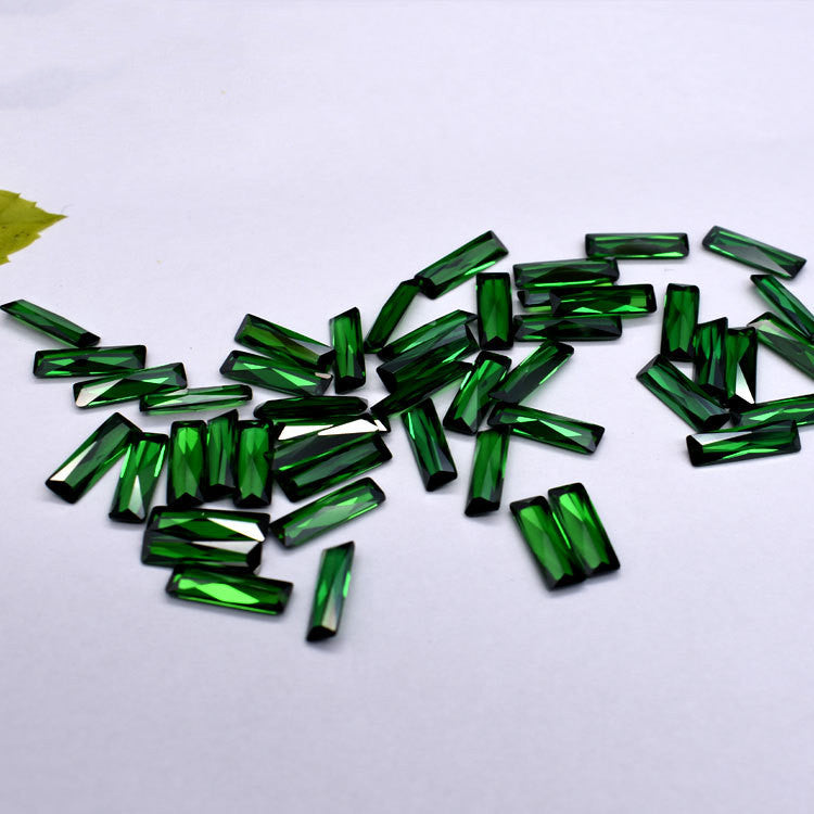 Green gemstones scattered on a white background