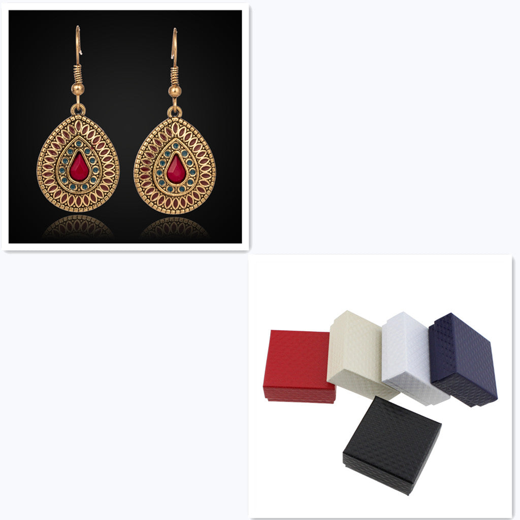 Pair of gold earrings with red gemstones and four jewelry boxes in different colors.