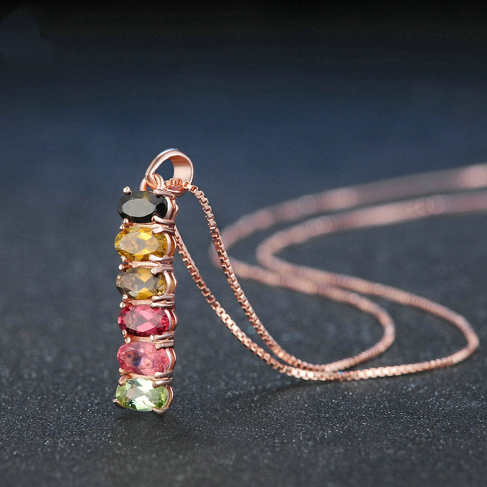 Necklace with a pendant featuring multicolored gemstones on a dark background