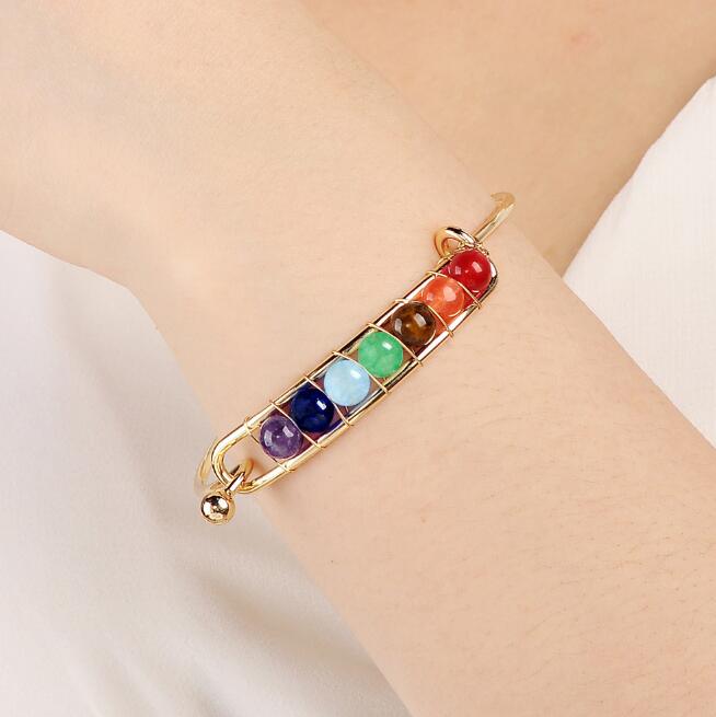 Bracelet with colorful beads on a wrist against a neutral background