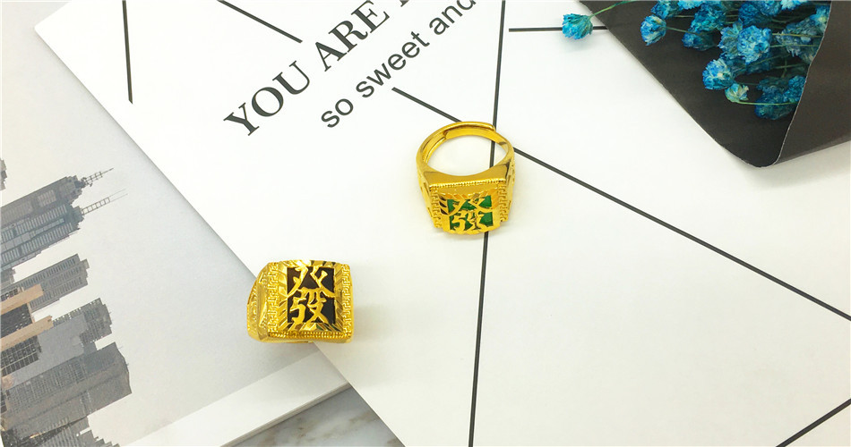 Two gold rings on a white surface with text and flowers in the background