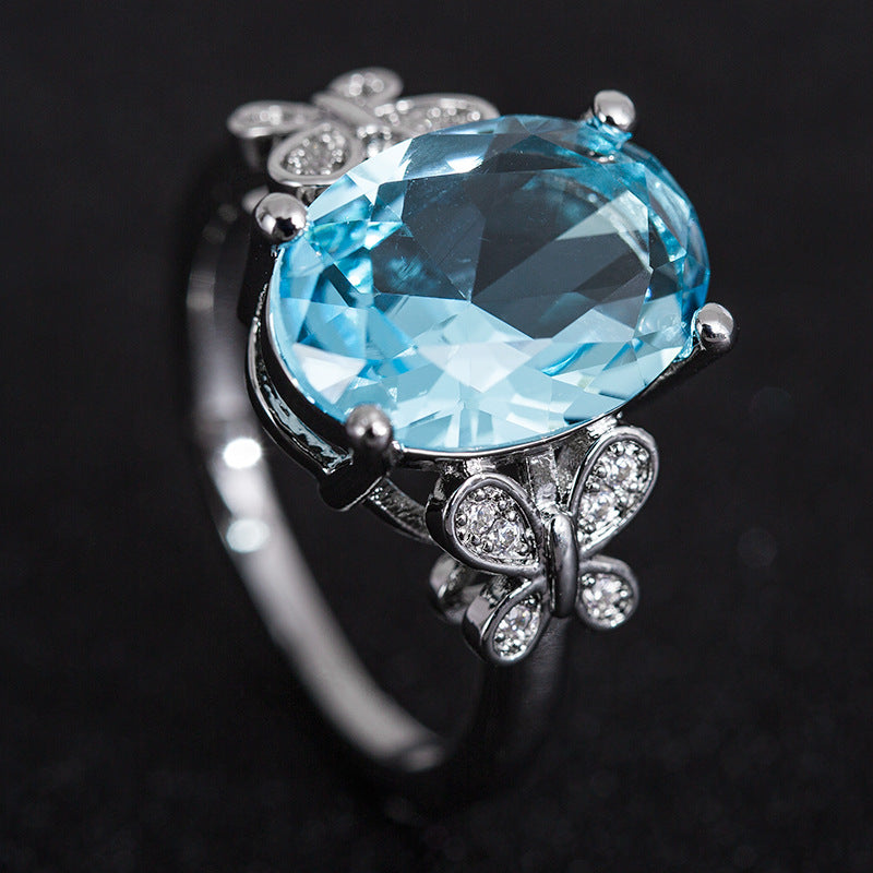 Ring with a large blue gemstone and silver accents on a dark background