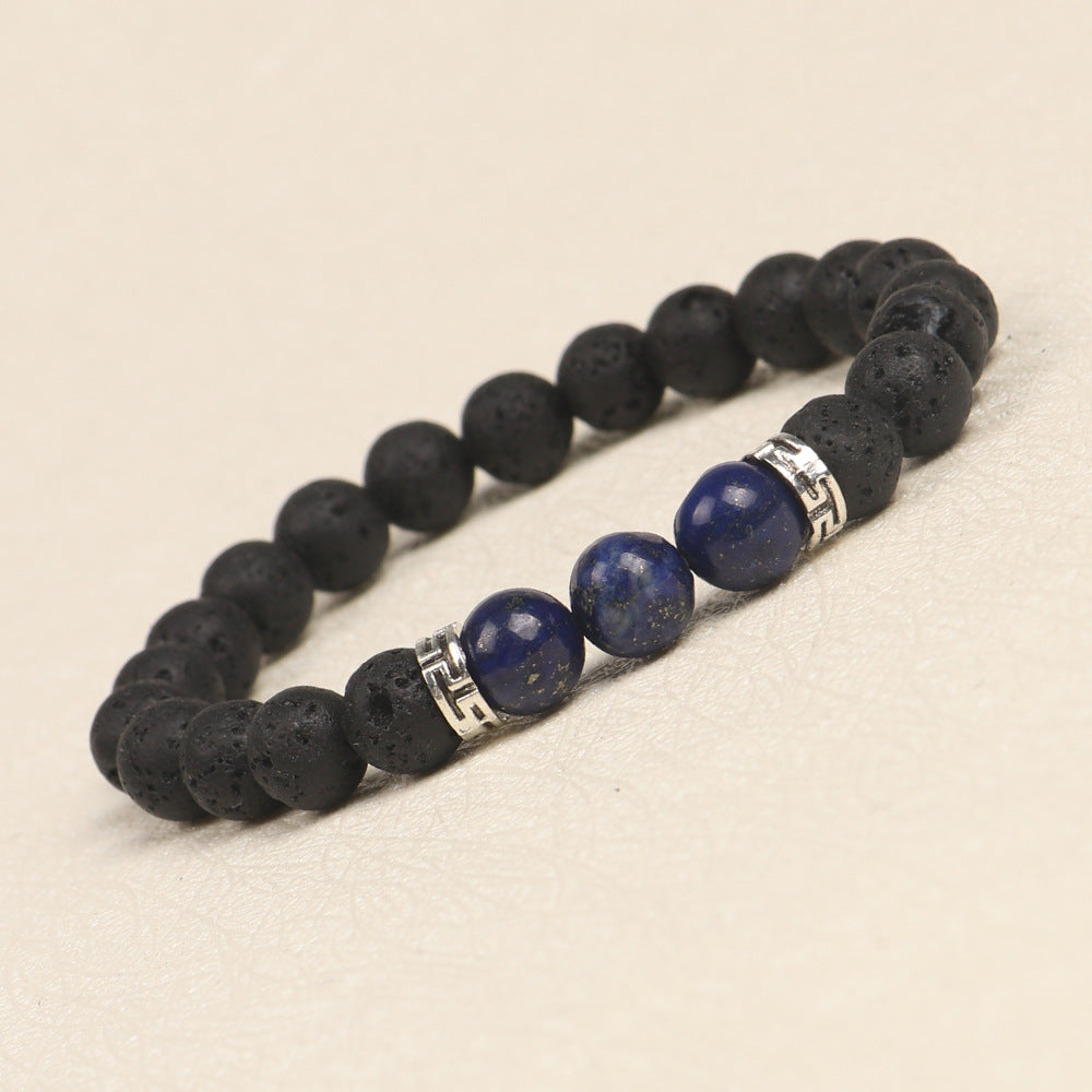 Black lava stone and blue stone bracelet with silver accents on a beige background