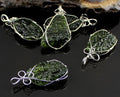 Set of green stone pendants with silver wire wrapping on a dark surface