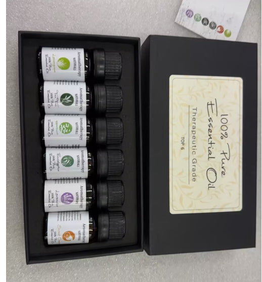 Set of essential oil bottles in a black box with a label on a gray background