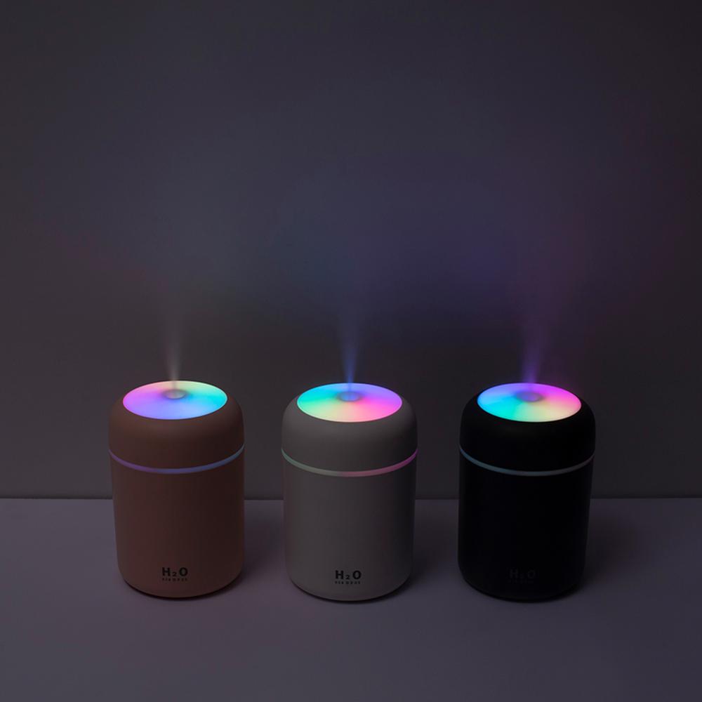 Three colorful humidifiers on a dark background