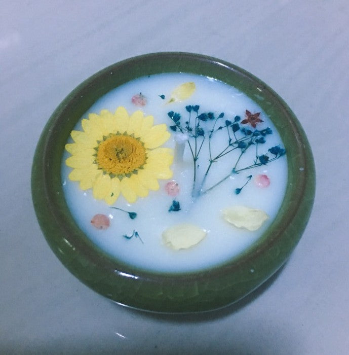 Decorative dish with a yellow flower and green leaves on a white background