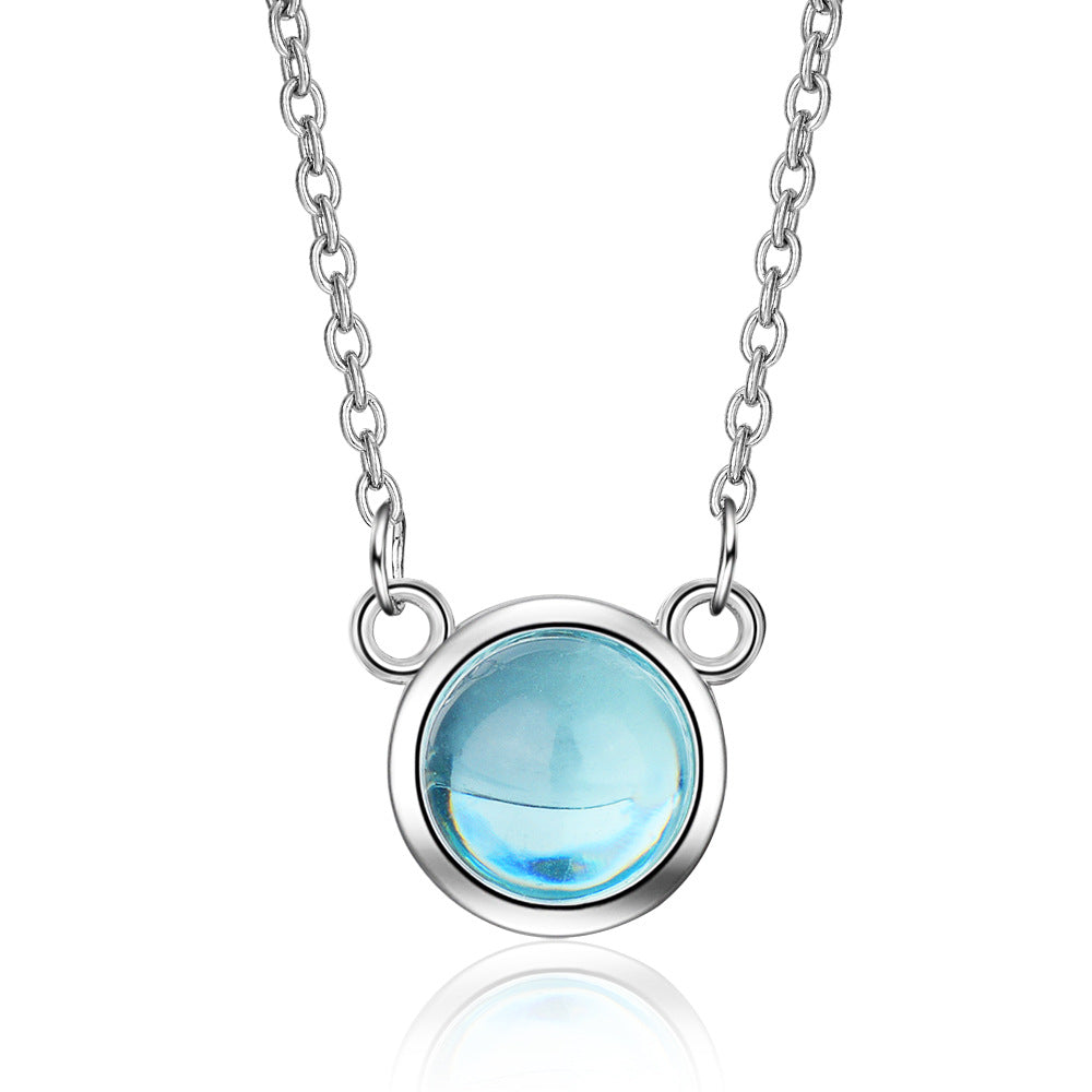 Silver necklace with a blue gemstone on a white background