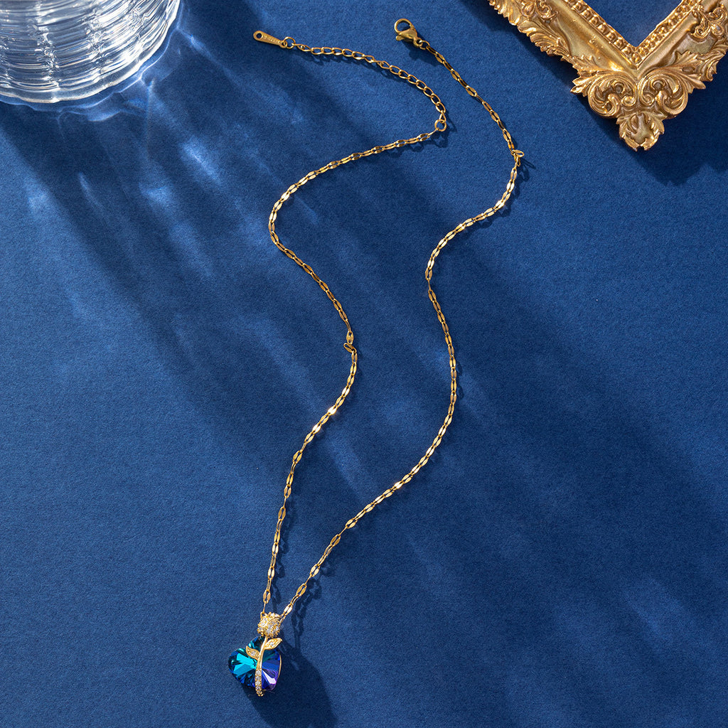 Gold necklace with a blue pendant on a blue background