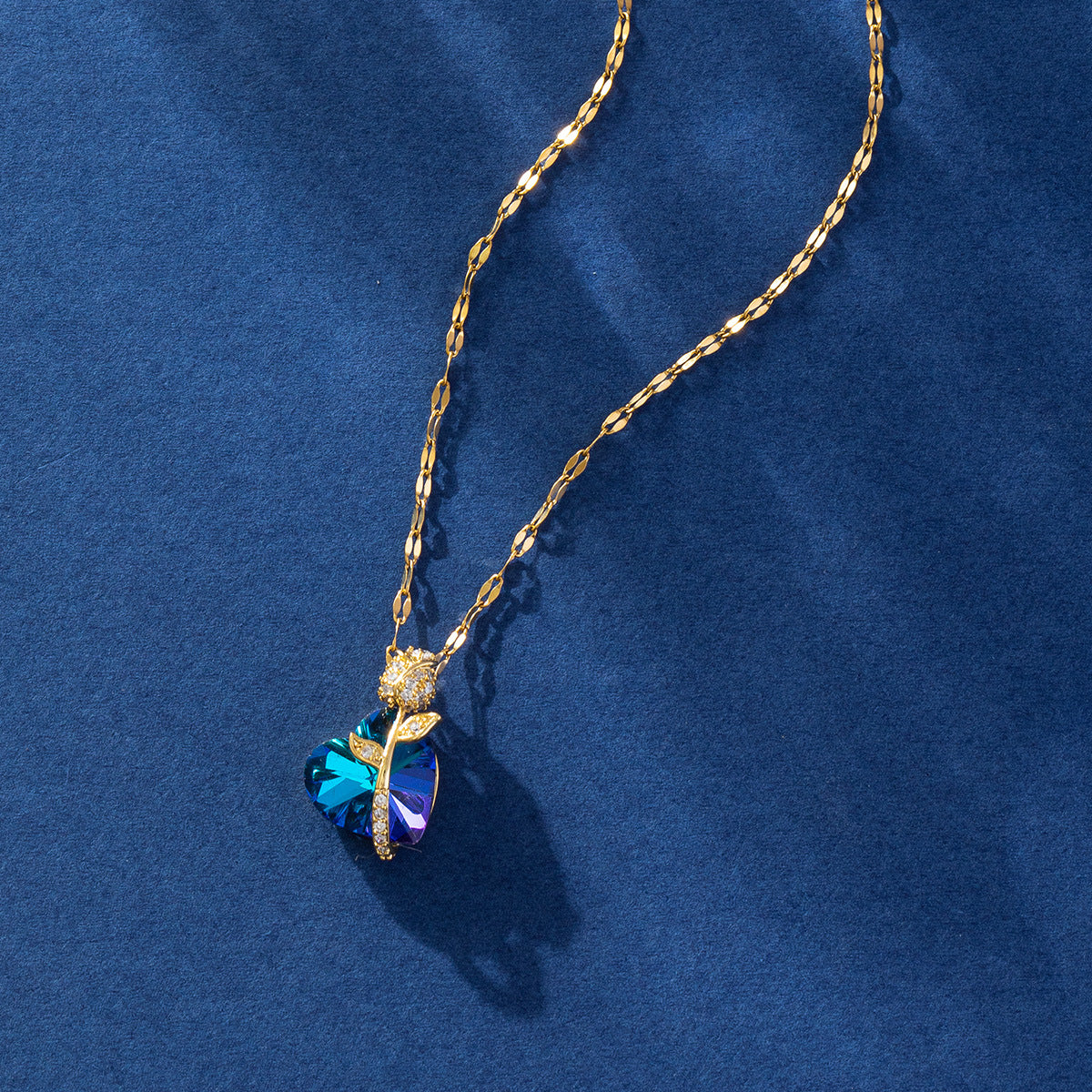 Gold necklace with a blue heart-shaped pendant on a blue background
