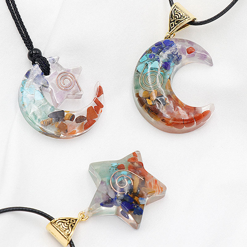 Three colorful stone pendants shaped like a star and crescent moon on black cords against a white background.