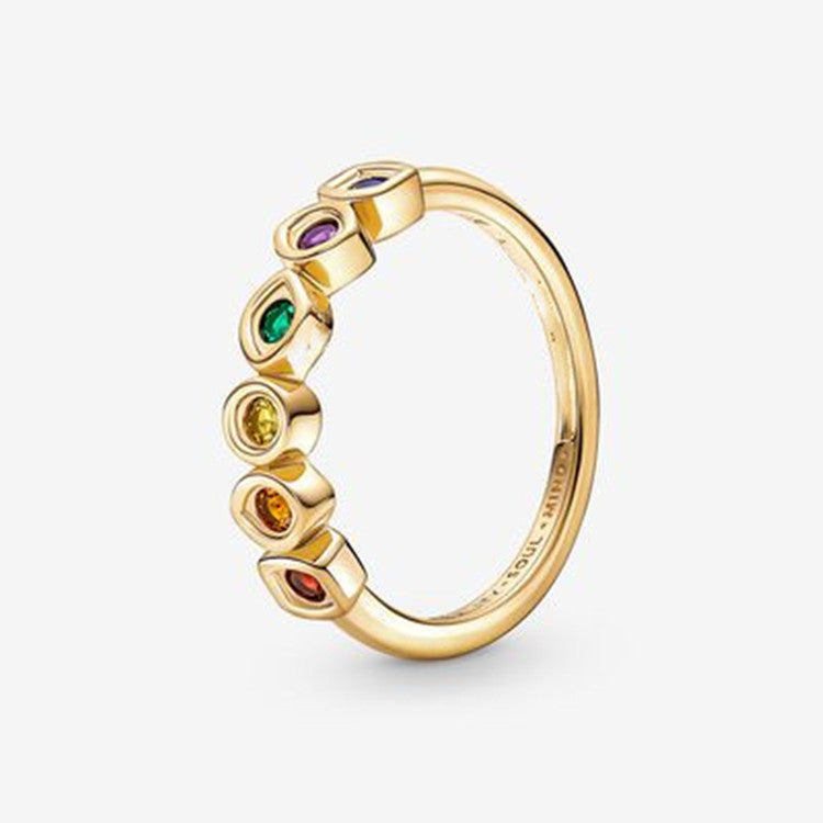 Gold ring with colorful gemstones on a white background