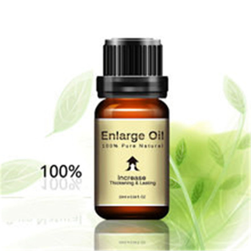 Bottle of 'Enlarge Oil' with green leaves on a white background