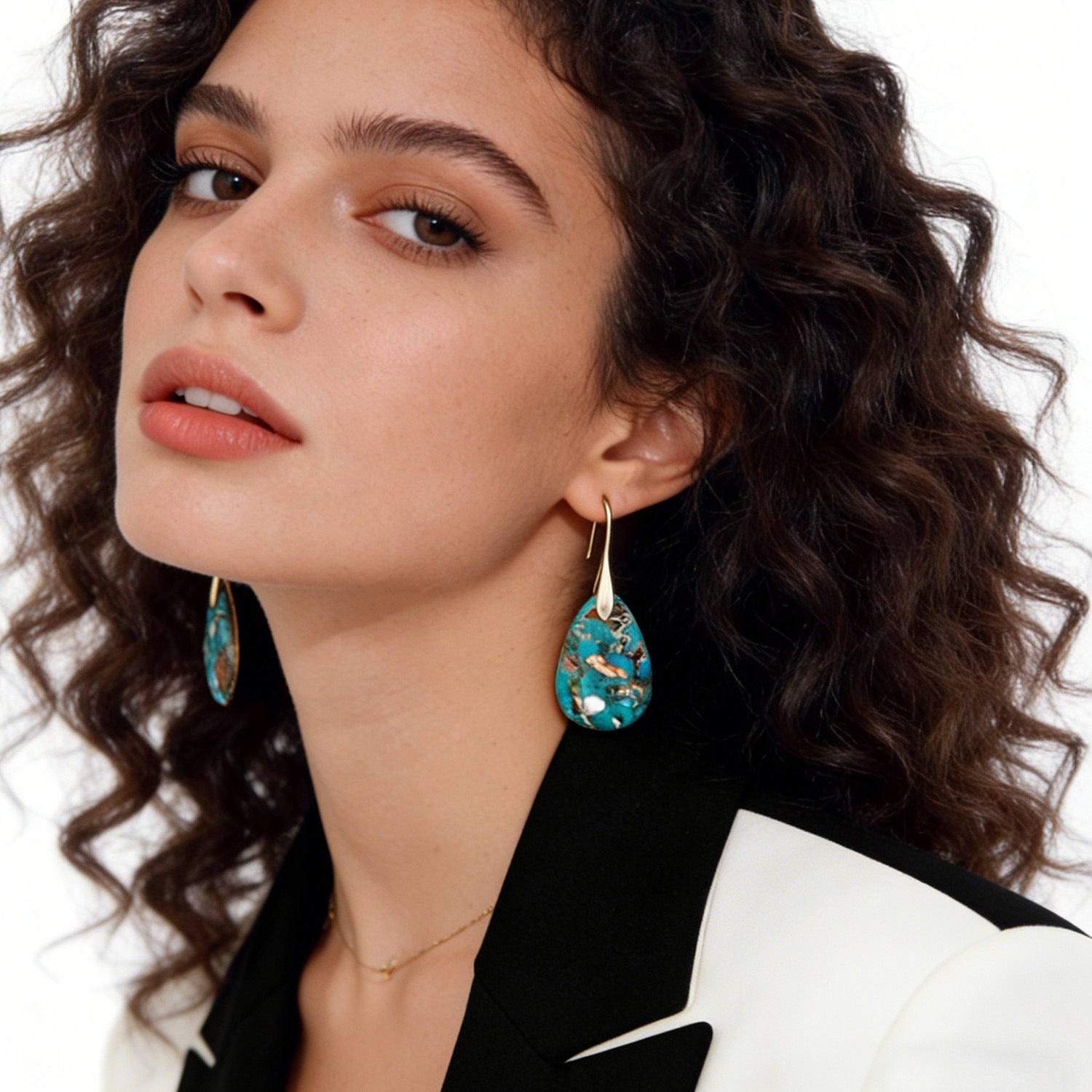 Woman wearing turquoise earrings with a neutral background
