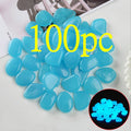 100 blue glow-in-the-dark pebbles on a white surface with an inset showing their glow.