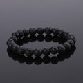 Black beaded bracelet on a reflective black surface