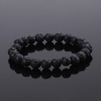Black beaded bracelet on a reflective black surface